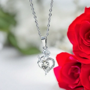 Detail of silver heart pendant necklace with rose design and sparkling central zircon