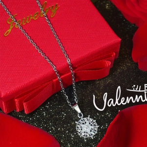 Silver snowflake mandala pendant necklace with pearls on a red gift box background