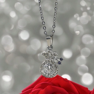 Vue détaillée du pendentif sac d'argent serti de strass avec perle bleue et chaîne