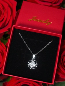 Close-up of sparkling floral pendant necklace in a red Jewelry gift box with roses