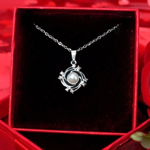 Gros plan d'un pendentif perle tournesol en argent avec diamants dans un coffret cadeau rouge
