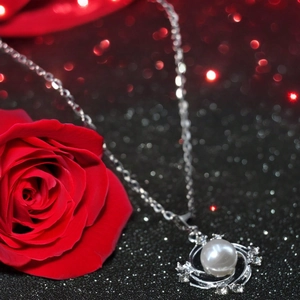 Collier élégant avec perle de tournesol et chaîne en argent S925 sur fond de rose rouge