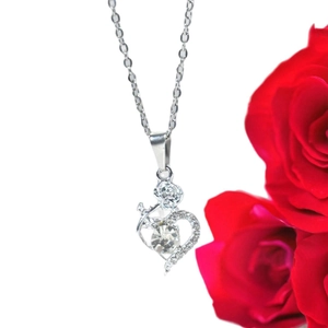 Silver heart necklace with rose design and crystal pendant on a romantic floral background