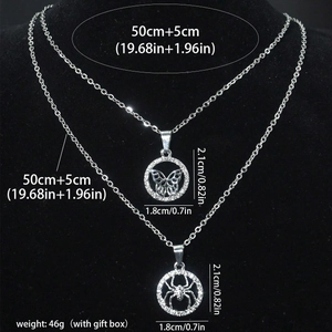 Détails des pendentifs araignée et papillon sertis de cristaux sur support noir