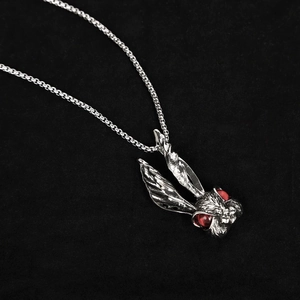 Punk style titanium steel rabbit pendant with red eyes on black velvet background