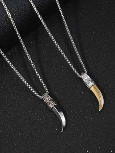 Détail du pendentif dent de loup avec capuchon gaufré vintage et chaîne à mailles carrées