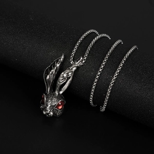 Close-up of vintage titanium steel rabbit pendant with red gem eyes and round box chain
