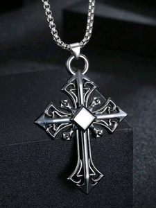 Macro view of gothic silver cross pendant with hollow patterns and box chain detail