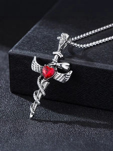 Macro view of gothic sword pendant with red heart gemstone and coiled snake detail