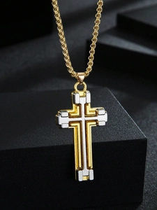 Close-up of two-tone gold and silver layered cross pendant necklace on a box chain
