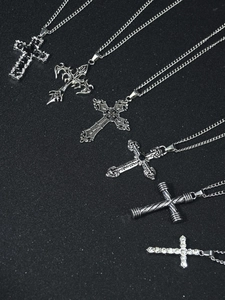 Detail view of six silver cross necklaces with gothic and hip hop designs on black background