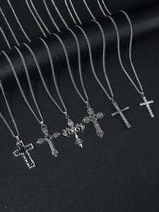 Detail of six silver cross necklaces with gothic and modern hip-hop styles on black display