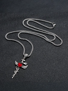 Detail of vintage gothic sword pendant with winged snake and red heart crystal