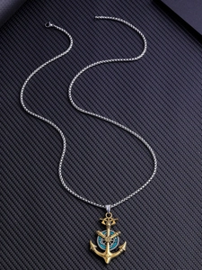 Détail du pendentif ancre vintage avec incrustation turquoise et chaîne argentée