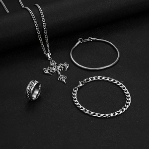 Set gioielli con collana croce, bracciale a catena e anello su sfondo di pelle nera premium