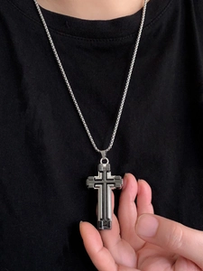 Close-up of a silver 3D layered cross pendant with black inlay on a square pearl chain