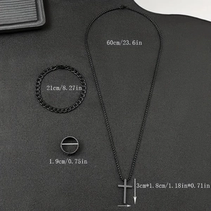 Flat lay of matte black stainless steel cross necklace, cuban bracelet and ring set