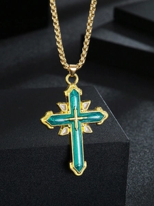 Détail du collier croix vintage doré avec émail vert émeraude et accents blancs