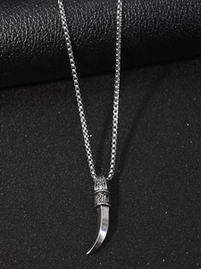 Vue détaillée du pendentif dent de loup vintage avec relief gothique sur acier poli