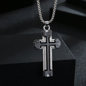 Men's two-tone silver and black stainless steel cross necklace on black display