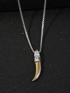 Gros plan sur le placage en argent gravé d'un pendentif dent de loup luminescent