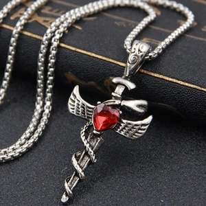 Gothic silver sword necklace with wings and red heart gemstone on black background