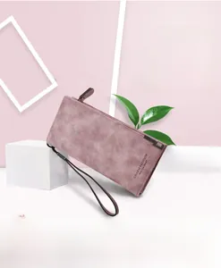 Detailed close-up of matte long wallet for women with wrist strap and zipper in dusty pink