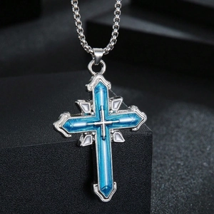 Collier à pendentif croix bleue multicouche exposé sur un socle géométrique noir