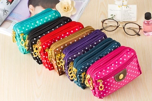Detailed view of canvas polka dot pouches with triple zippers in seven vibrant colors
