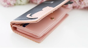 Detail of pink and black cat-shaped wallet featuring multiple card slots and zip pocket