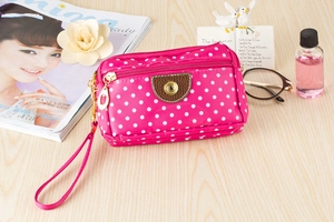 Detailed macro view of the rose red polka dot canvas bag with multi-layer gold zippers