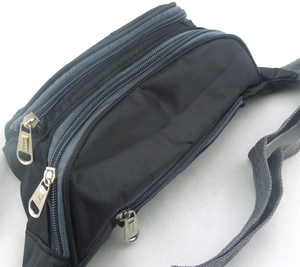 Detail view of multi-pocket nylon waist bag featuring three layered zipper compartments