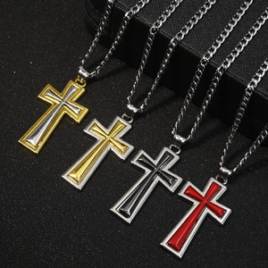 Collection de colliers pendentifs croix bicolores polis sur un présentoir noir