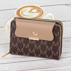 Petit portefeuille marron à monogramme pour femme sur table en bois avec café latte