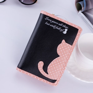 Close-up of pink and black cat wallet with polka dot details and chic lifestyle props