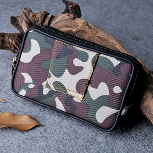 Tactical camouflage canvas waist bag with dual zippers on a dark textured background