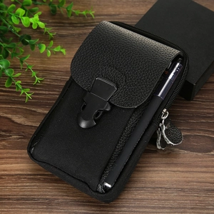 Detail of black tactical waist bag with buckles, zippers and a pen slot on wood surface
