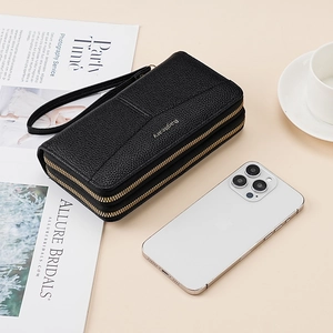 Detail of black pebbled leather texture on double zipper wallet with detachable wrist strap