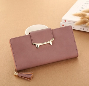 Detail of mauve PU leather wallet featuring golden cat-ear clasp and tassel pendant