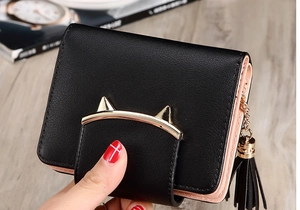 Close-up of black PU leather wallet with pink interior, cat ear clasp and tassel detail