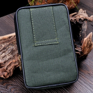 Army green tactical nylon belt pouch with metal ring zipper on outdoor wood background