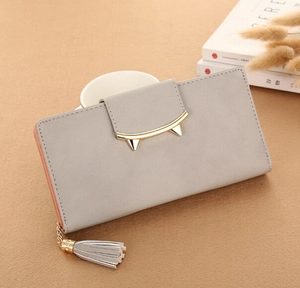 Detail of grey long wallet featuring a cat-ear gold clasp and elegant tassel charm