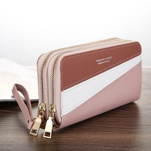 Detail view of pink and white color-block long wallet with double gold zippers and wrist strap