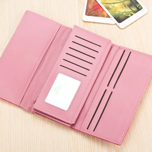 Internal view of pink multi-slot trifold wallet with ID window on a wooden desk
