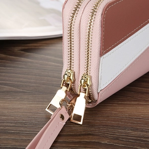 Detail of dual gold zippers and premium lychee texture on tri-color leather wristlet