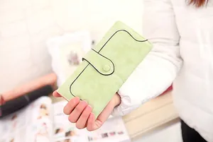 Detail of mint green frosted texture long wallet with snap strap and black trim accents