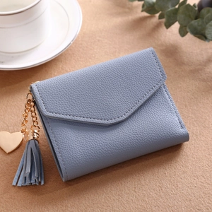 Detail of light blue litchi grain leather wallet with gold heart and tassel charm