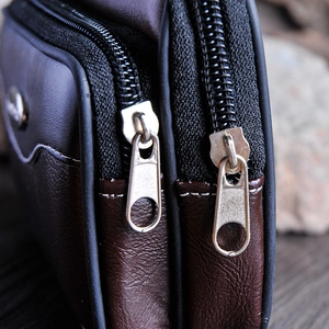 Macro view of dual-zipper closure and lychee texture on men's leather waist bag
