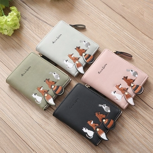 Detail of colorful mini wallets featuring animal embroidery and plush tail zippers