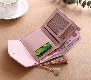 Detail of pink lychee grain wallet interior with card slots and a tassel pendant